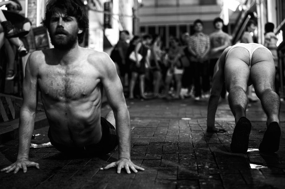 Two half naked guys doing strange exercises at Lan Kwai Fong