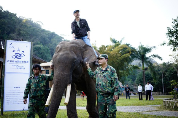 Parisian Chinese photographer Zeng Nian rides an elephant to collect his award.