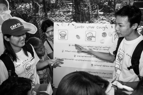 Volunteers talking to villagers about Tuberculosis prevention and health matters at 